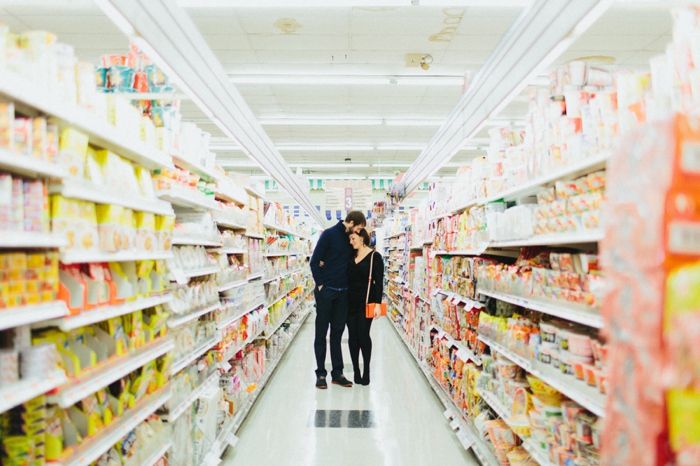 two people standing in the aisle of a grocery store