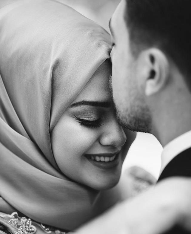 a man and woman kissing each other with their heads covered in veils, black and white photo