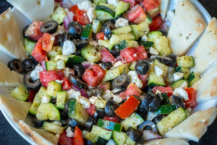 a bowl filled with vegetables and pita bread