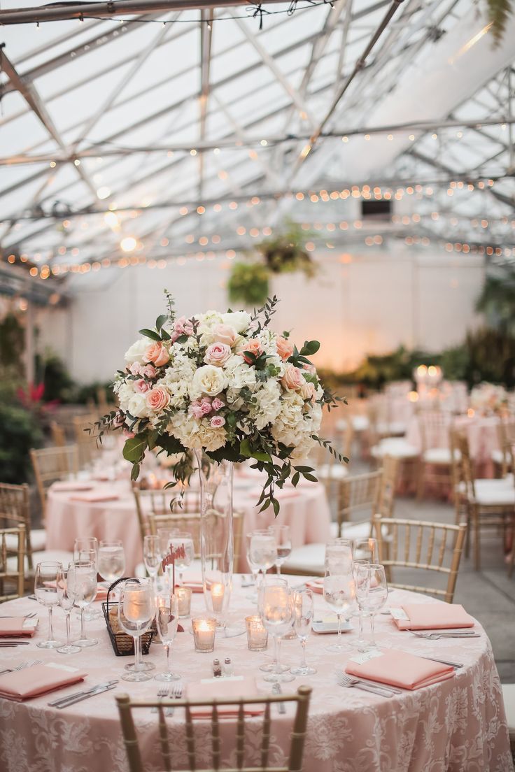 an indoor wedding reception with pink and white flowers