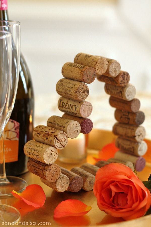 wine corks are arranged in the shape of a trellis on a table with rose petals