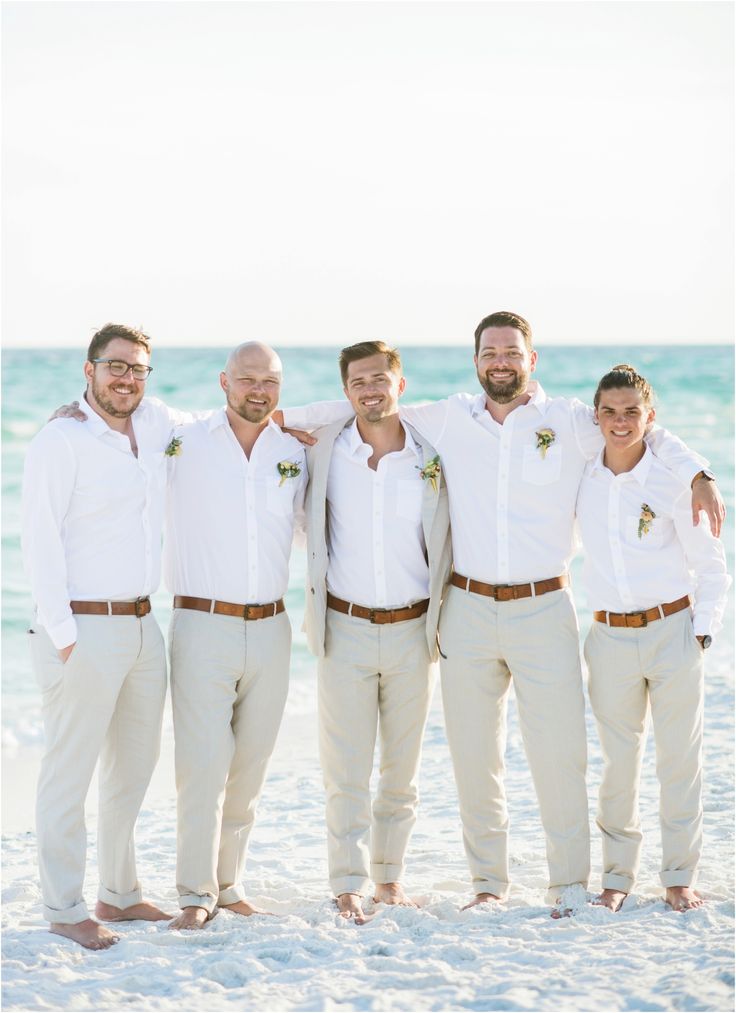 a group of men standing next to each other on a beach