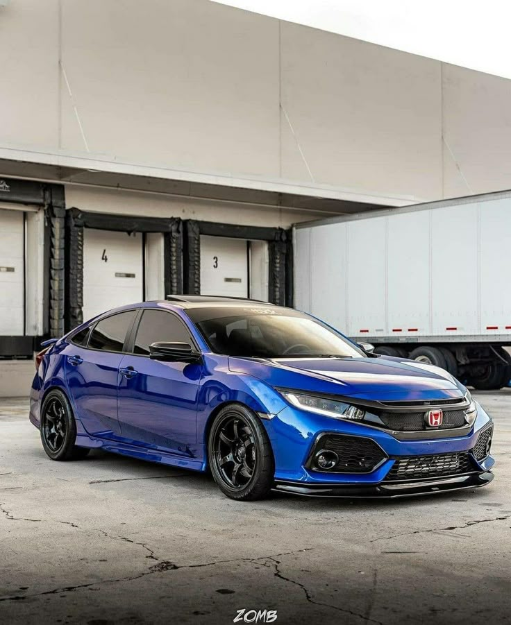 a blue car parked in front of a white truck