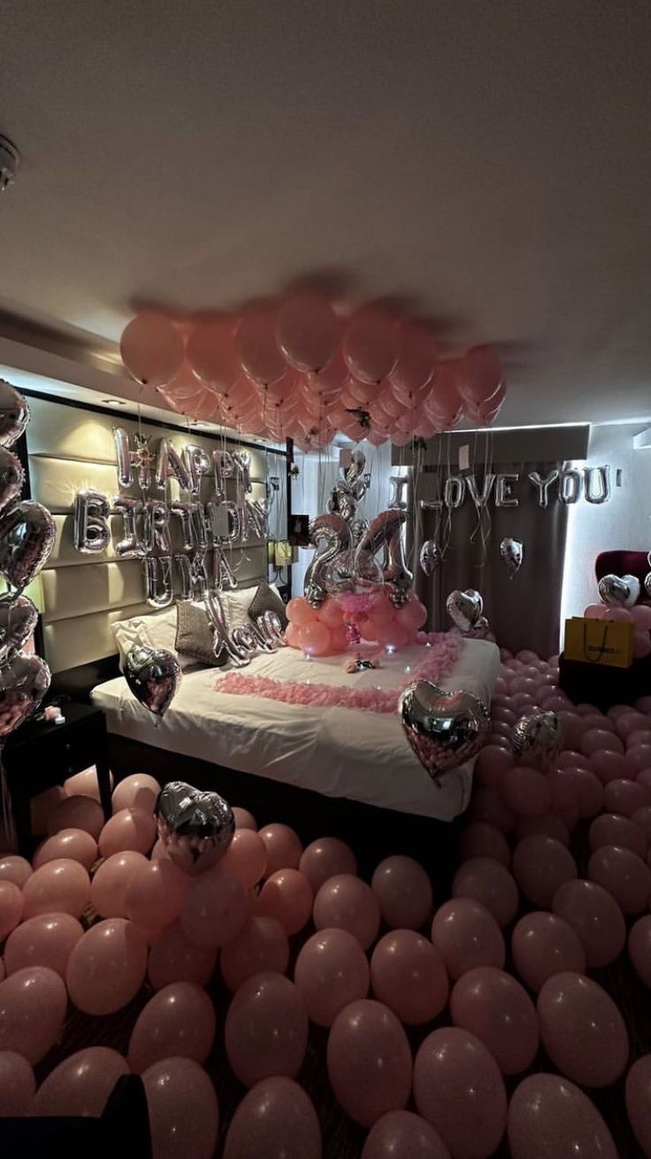 a room filled with pink and silver balloons