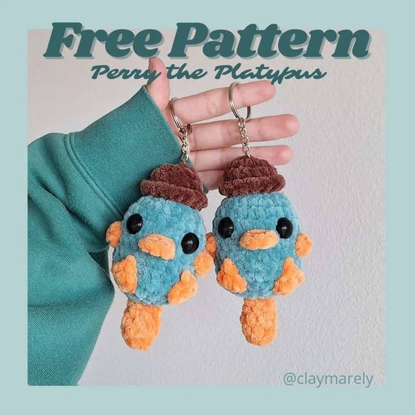 a pair of blue and orange stuffed animals hanging from a keychain that says free pattern ferry the platypus