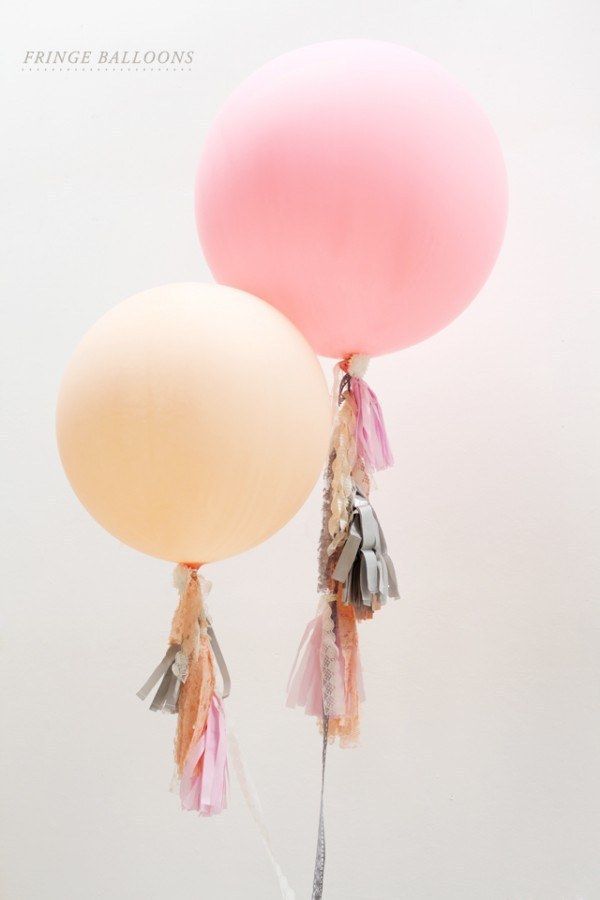 two balloons with tassels attached to them