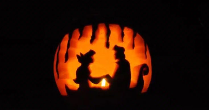 a pumpkin carved to look like two people holding hands