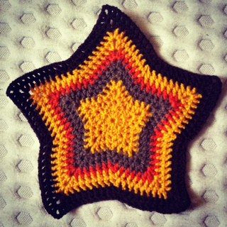 a crocheted star ornament sitting on top of a bed