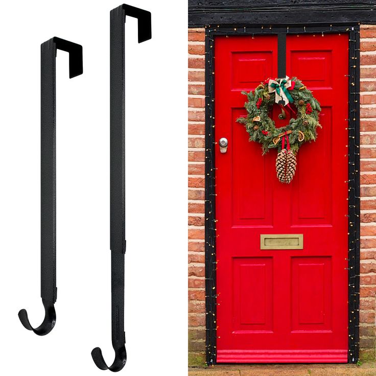 a red door with a wreath hanging on it's side and a pair of black metal hooks