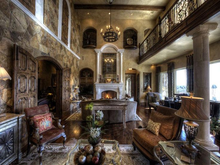 a living room filled with lots of furniture and a fire place in the middle of it