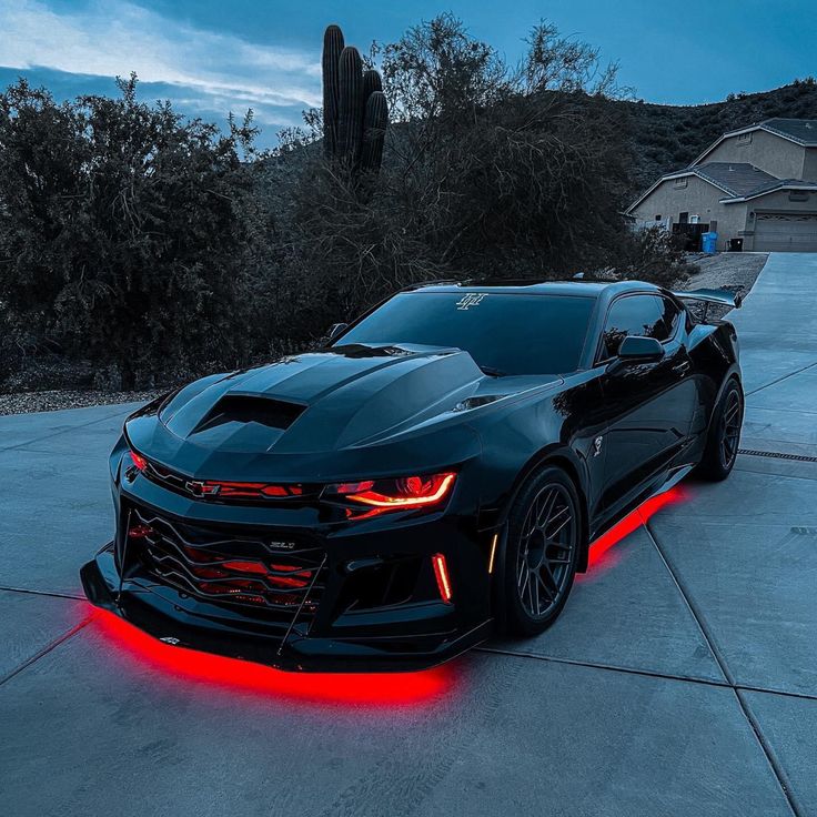 a black chevrolet camaro with red lights on it