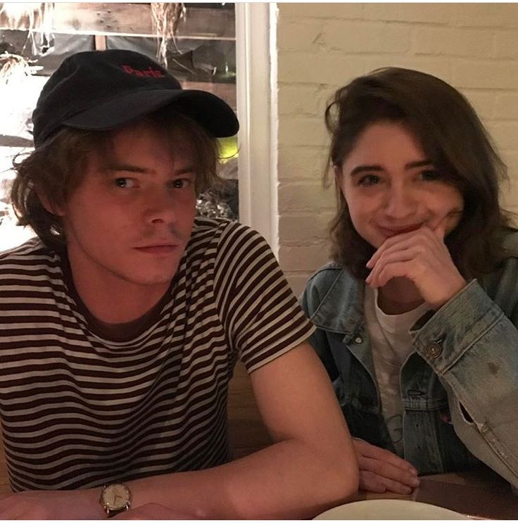 two people sitting at a table with plates of food