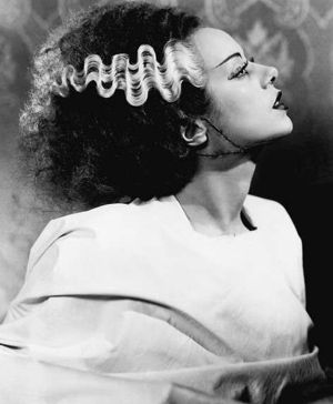 an old black and white photo of a woman with curls in her hair looking to the side