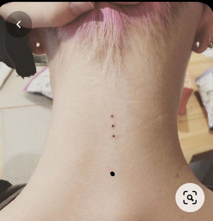 the back of a woman's neck has a tiny dot on her left side