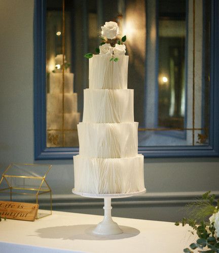 a three tiered white cake sitting on top of a table