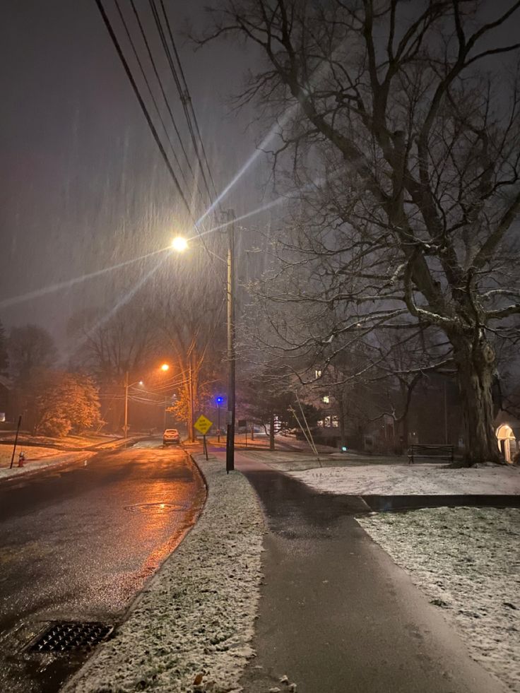 the street is covered in snow at night with no one on it or any cars