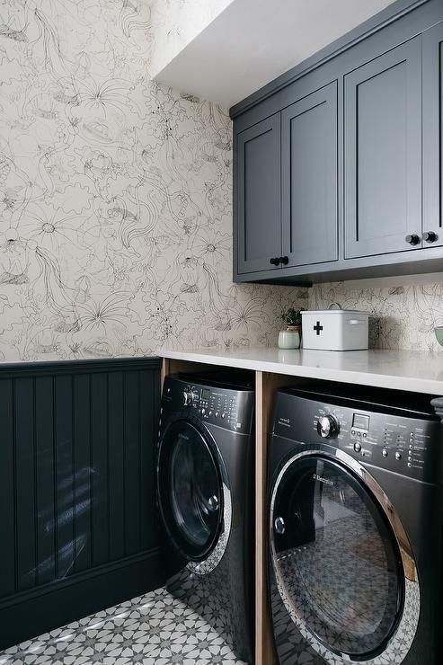 a washer and dryer in a small room with wallpaper on the walls