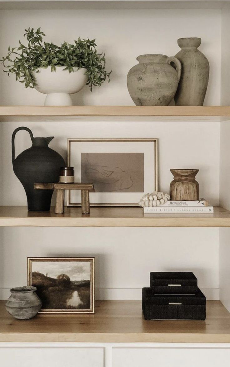 shelves with vases, books and pictures on them