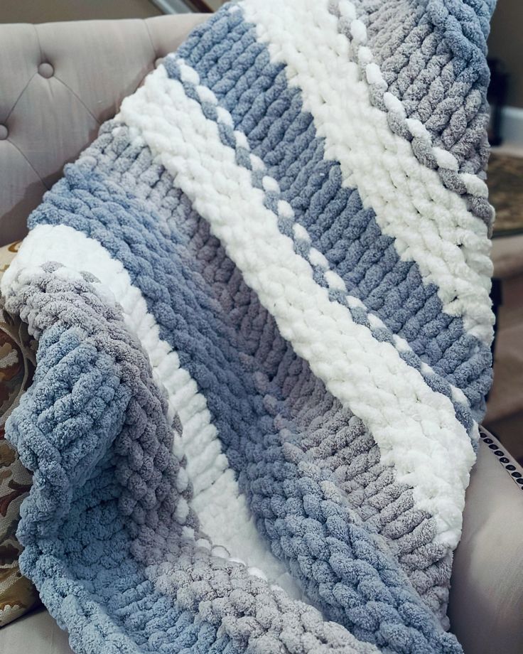 a blue and white blanket sitting on top of a chair