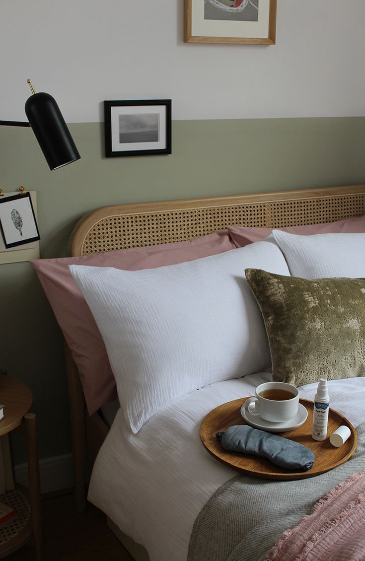 a tray with two cups of coffee sitting on top of a bed next to pillows