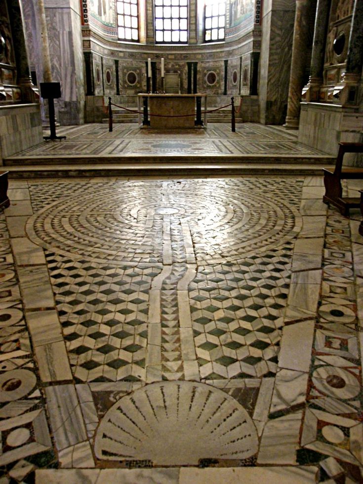 the inside of an old church with marble flooring and pews on either side