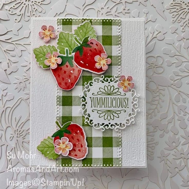 a close up of a greeting card with strawberries on the front and green gingham background