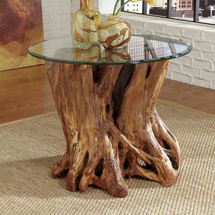 a glass top table with a tree stump base