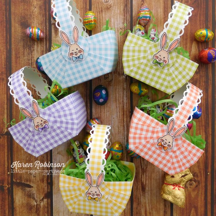 easter baskets with bunnies and flowers in them on a wooden table next to eggs