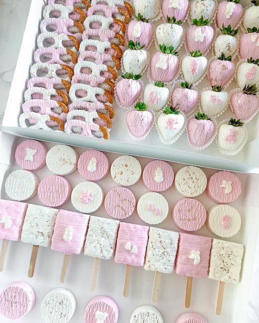 pink and white desserts are arranged on sticks