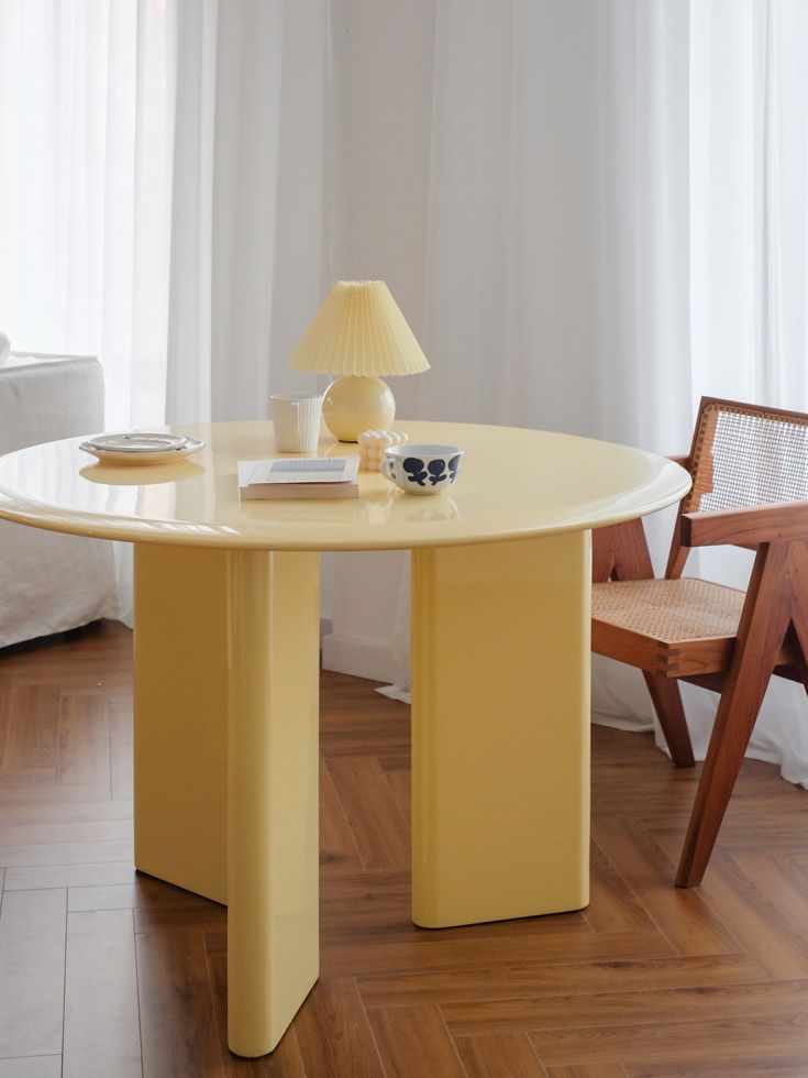 a yellow table with two chairs and a lamp