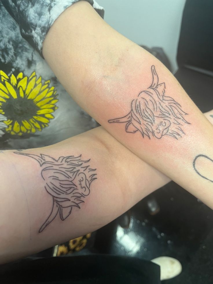 two people with matching tattoos on their arms