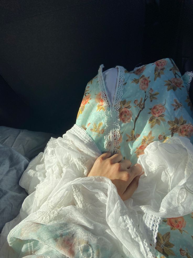 a woman laying on top of a bed under a blanket