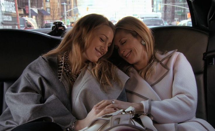 two women sitting in the back seat of a car