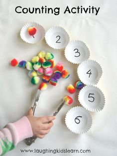 counting activity for toddlers with paper plates and spoons filled with candies on white background