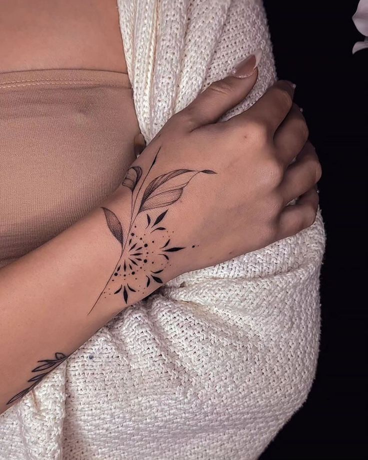 a woman's arm with a flower tattoo on the left side of her arm