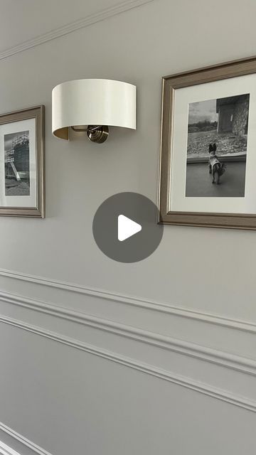 two pictures hanging on the wall next to a lamp