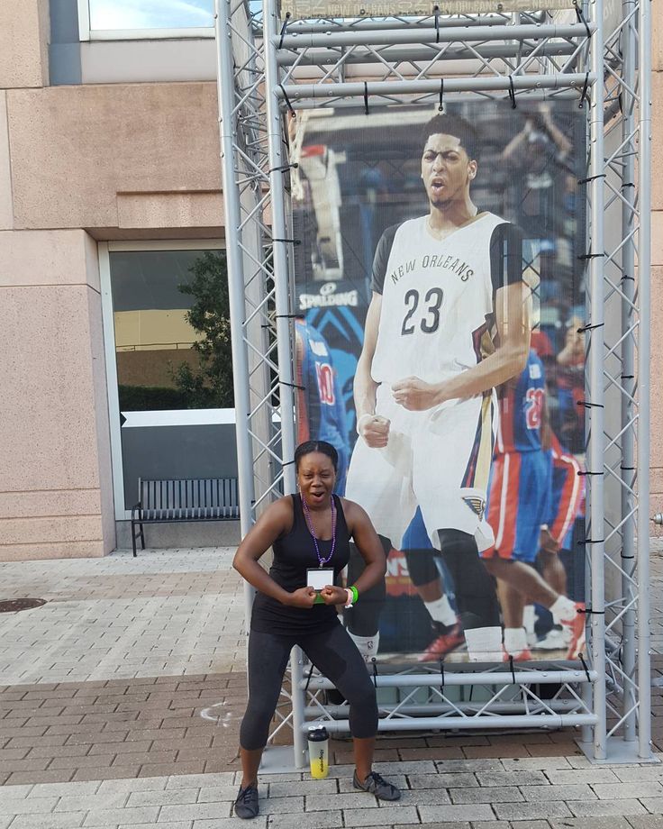 a woman kneeling down in front of a large poster on the side of a building