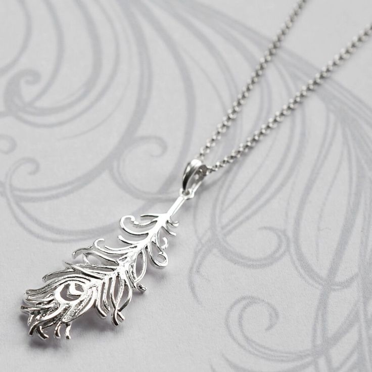 Our beautiful Silver Peacock Feather Necklace is bound to add glamour to any outfit! This gorgeous peacock feather necklace makes the perfect gift for someone who likes to stand out from the crowd. The peacock feather symbolises compassion and integrity, the perfect gift for someone who deserves a special thank you. We don't mind if you treat yourself either...we promise not to tell! Why not make this gift truly personal by adding an initial charm letter All Martha Jackson jewellery comes in a gift box with a small gift card for you to write a message on.  made from: Sterling Silver. Keep clean with an anti tarnish cloth. dimensions: Pendant 4cm x 1.8cm  Add on initial letter charms approximately 1cm. Necklace Length -Short 35-40cm, Standard 40-45cm, 50cm, Long 61cm and Extra long 76cm. Hololive Council, God Jewellery, Peacock Feather Pendant, Peacock Feather Earrings, Feather Pendant Necklace, Bubble Earrings, Wire Jewellery, Peacock Pendant, Feather Necklace