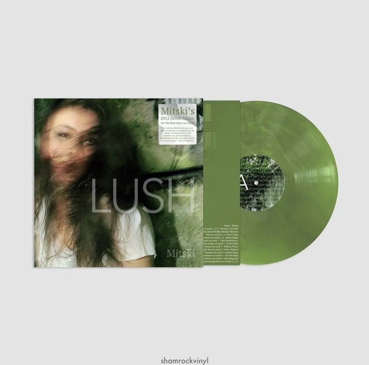 an image of a woman with long hair in front of a green vinyl album cover