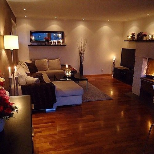 a living room filled with furniture and a fire place next to a wall mounted tv