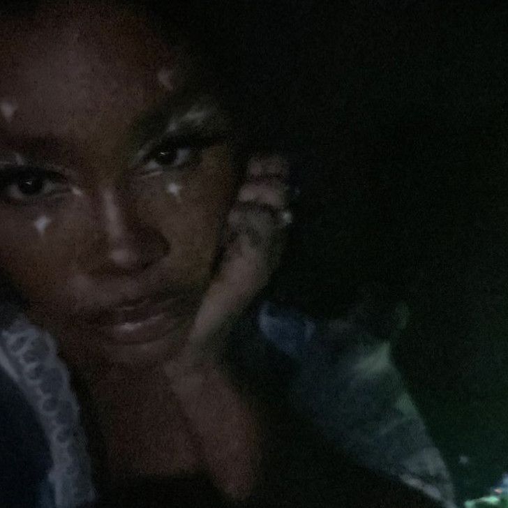 a close up of a person talking on a cell phone at night with the light reflecting off of her face