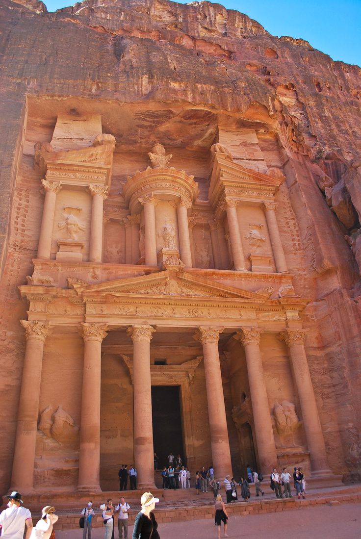 people are standing in front of an ancient building