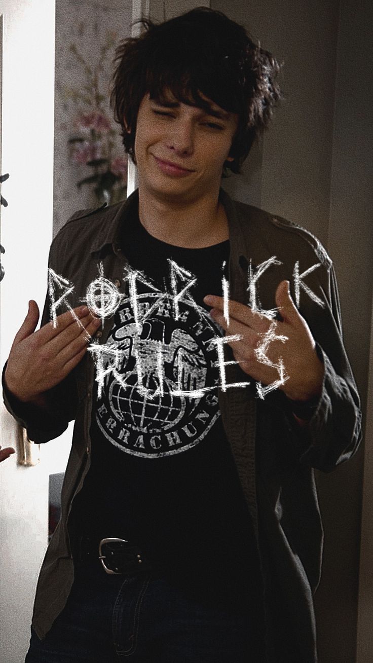 a young man standing in front of a mirror holding his hands up to the camera