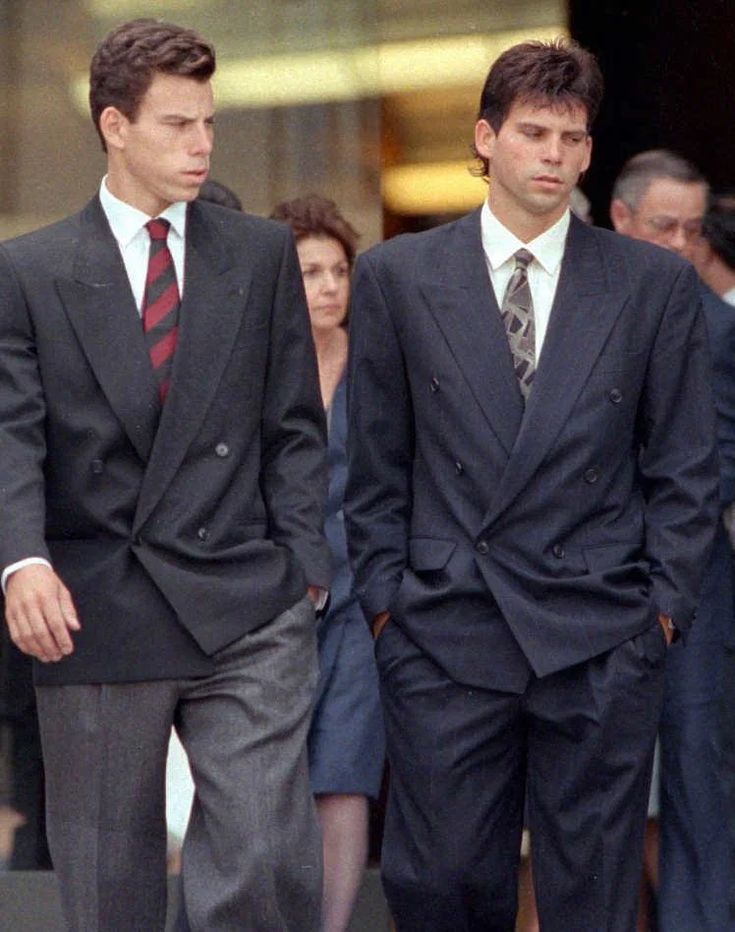 two men in suits walking down the street