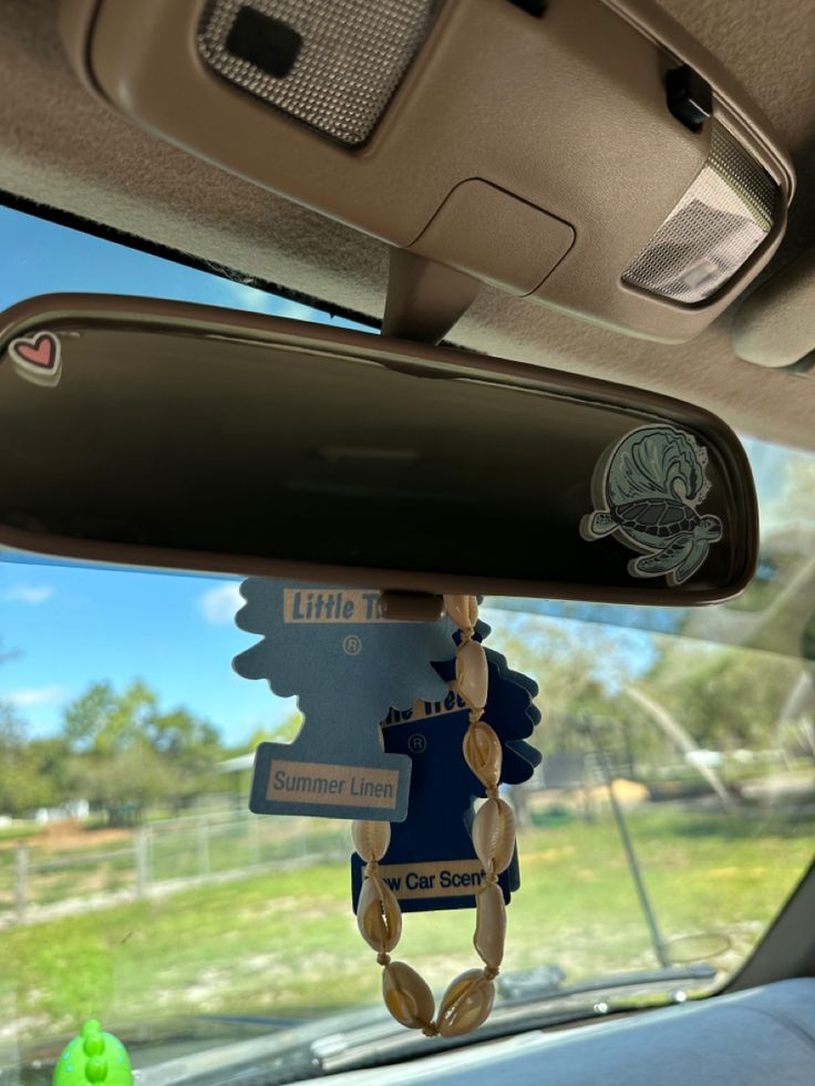 the interior of a car with an assortment of items hanging from it's rearview mirror