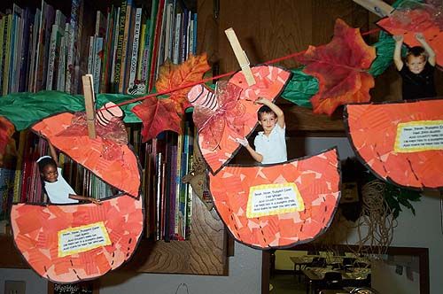 there are some paper pumpkins hanging on the wall