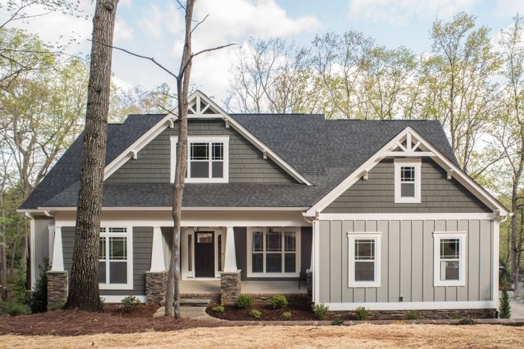 a gray and white house in the woods