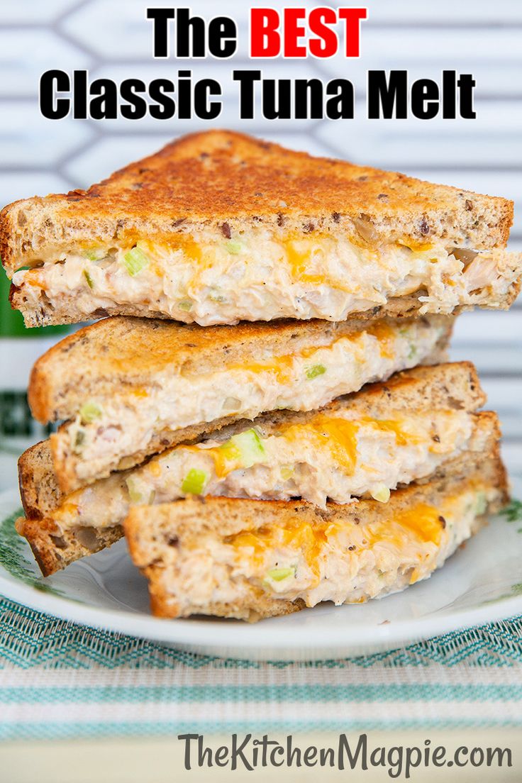 two sandwiches stacked on top of each other on a white plate next to a green cup