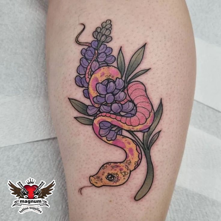 a snake and flowers tattoo on the leg