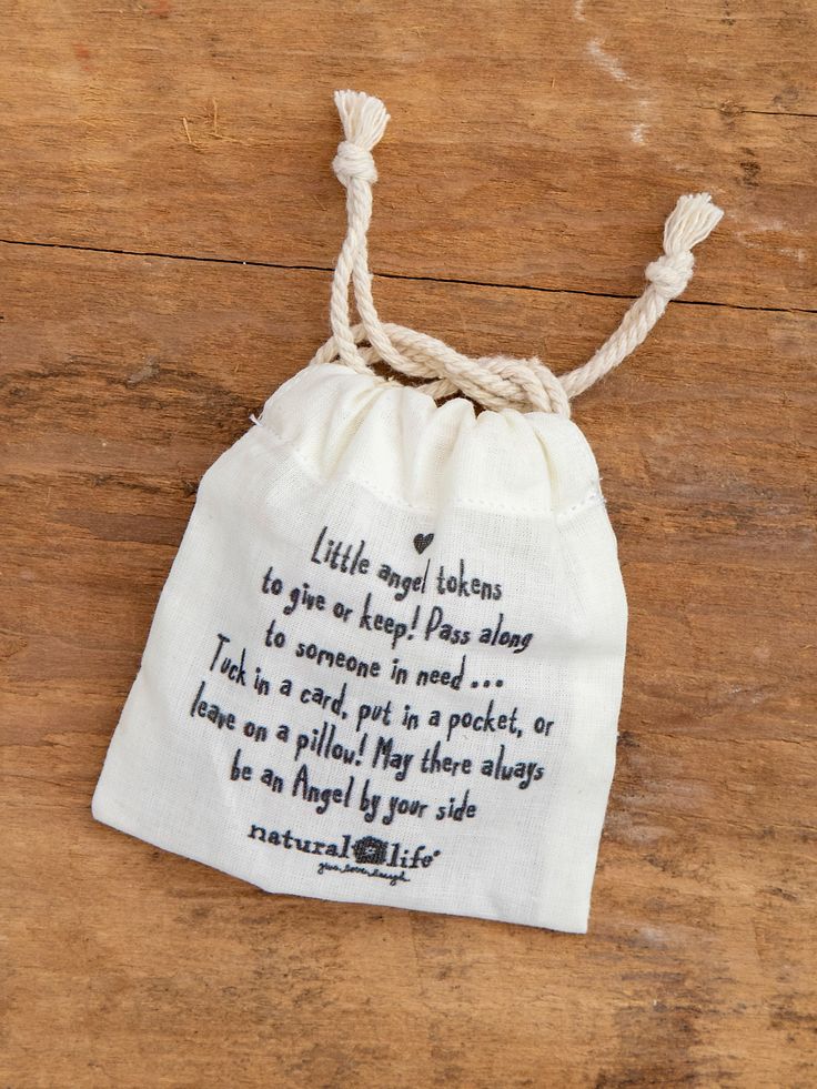 a white bag with a poem on it sitting on top of a wooden table next to a string